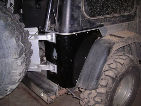 2003 Jeep TJ - Rear view of a black Jeep TJ showing aftermarket modifications to the corner and fender area.