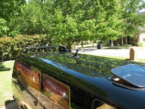 1978 Ford E250 - A black van features a custom mural on its side, depicting a sunset with a heart motif.