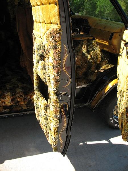1978 Ford E250 - Custom van interior features elaborate patterned upholstery and pinstriping on the door panel.
