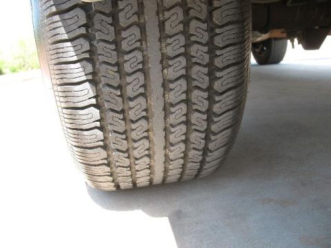 1978 Ford E250 - A close-up view of a tire tread, with a portion of the vehicle's undercarriage visible in the background.