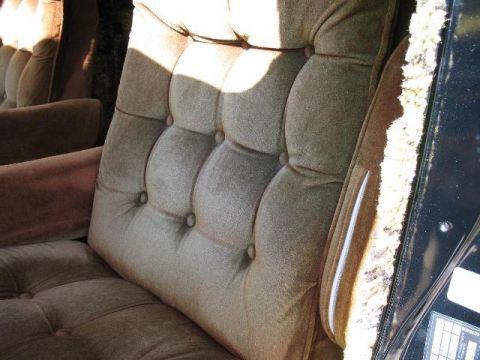 1978 Ford E250 - Interior view of tufted velour seats with sunlight casting shadows.