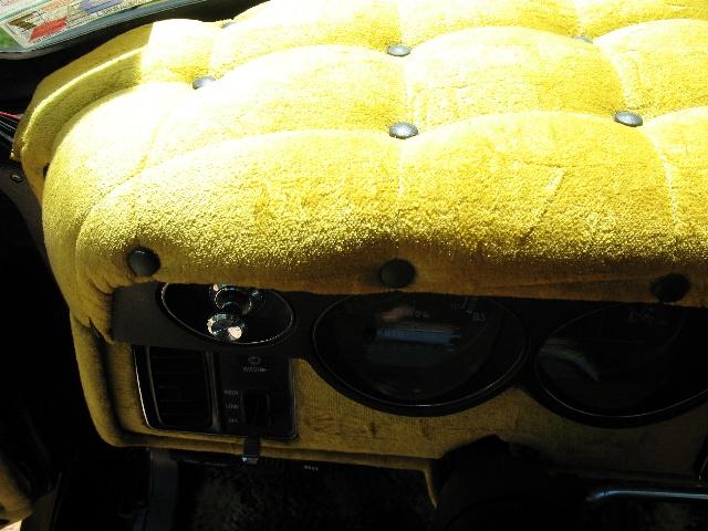 Yellow tufted dashboard with gauges and climate controls in a 1978 Ford E250