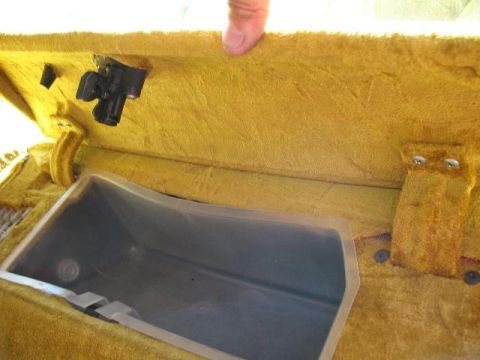 1978 Ford E250 - Interior view of a yellow glove box compartment, showing the latch and the empty bin.
