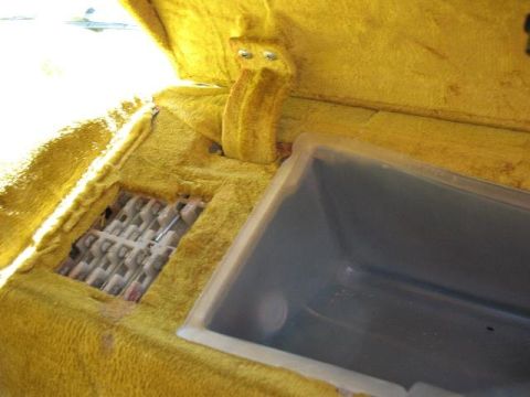 1978 Ford E250 - Interior view of a vehicle's carpeted console area with a storage bin and vent.