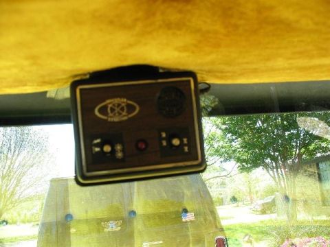 1978 Ford E250 - An aftermarket control unit is mounted to the headliner of a van, with a view of the exterior through the windshield.