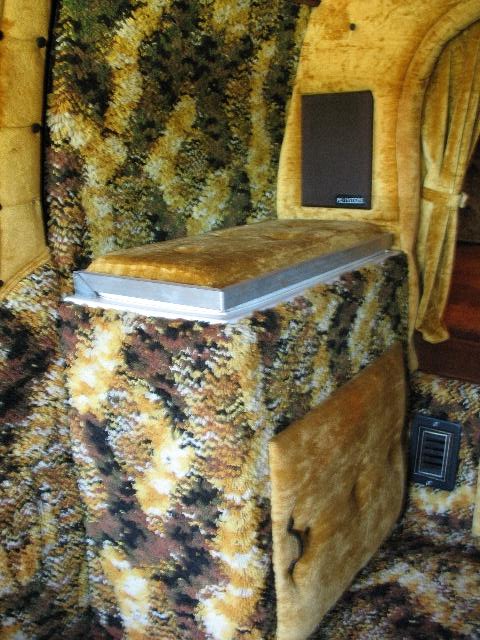 1978 Ford E250 - The interior of a van showcases unique upholstery and a built-in platform, with a visible speaker on the wall.