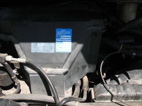 1978 Ford E250 - A close-up view of an engine compartment reveals a blue sticker with maintenance instructions and blank fields.
