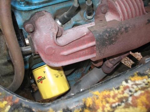 1978 Ford E250 - Close-up view of an engine's oil filter and exhaust manifold.