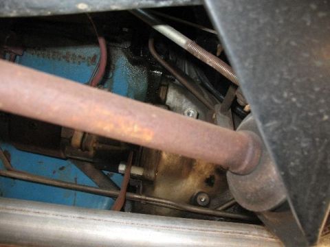 1978 Ford E250 - Underside view of engine components, showing a rusty exhaust pipe and blue painted engine block.