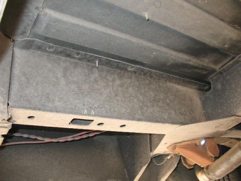 1978 Ford E250 - The underside of a vehicle shows structural components and exposed wiring.