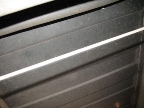 1978 Ford E250 - The underside of a vehicle, showing a series of horizontal ribbed panels, is captured in this image.