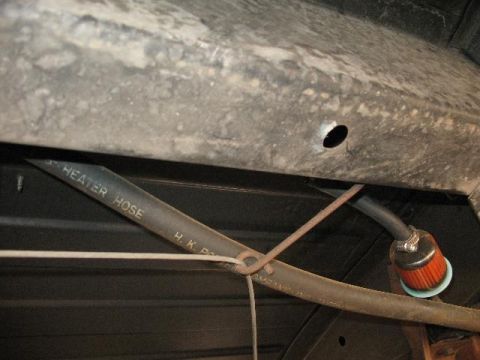 1978 Ford E250 - Close-up of a vehicle's undercarriage showing a heater hose and a fuel filter.