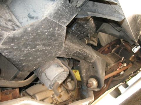 1978 Ford E250 - A close-up view of the undercarriage of a vehicle, revealing mechanical components and suspension elements.