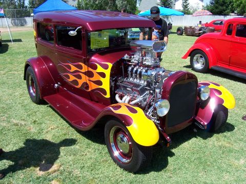2002 Ford Mustang - A custom hot rod with flame decals sits on a grassy field next to another vehicle.