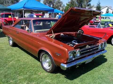 2002 Ford Mustang - Orange 1967 Plymouth GTX coupe at a car show, hood open, revealing the engine bay.