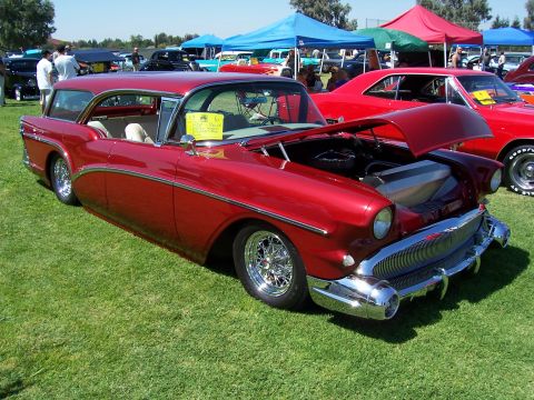 2002 Ford Mustang - A classic red station wagon is displayed with its hood open, its engine bay at an outdoor car show.