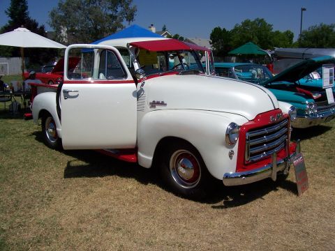 2002 Ford Mustang - A classic GMC pickup truck is displayed outdoors with other vehicles.