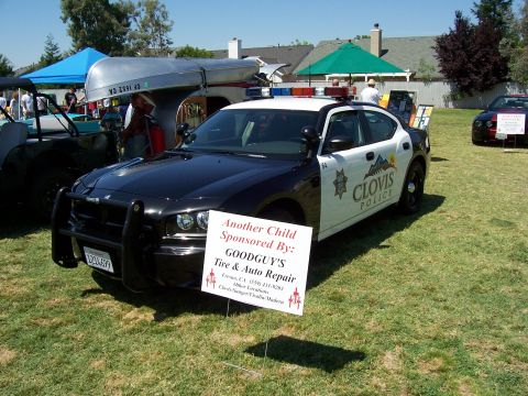 2002 Ford Mustang - A police car with "CLOVIS POLICE" text is displayed outdoors with a sponsorship sign in front.