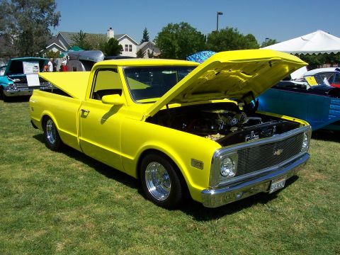 2002 Ford Mustang - A bright yellow pickup truck is displayed with its hood open, revealing the engine bay.