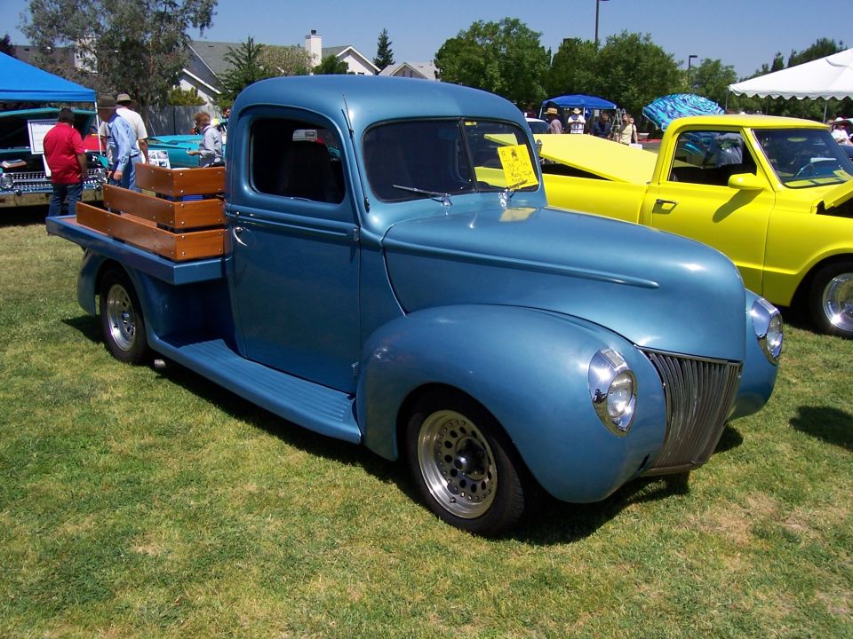 Blue classic pickup truck, 3/4 front view. Wooden bed inserts