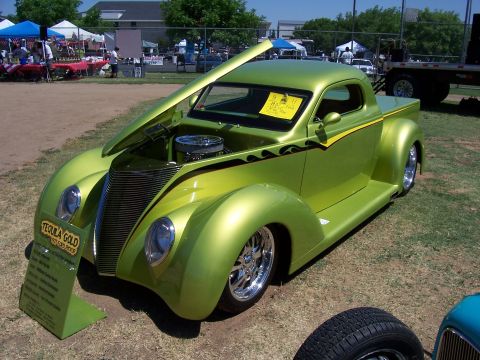 2002 Ford Mustang - A custom lime green pickup truck, identified as "Tequila Gold", is displayed with its hood open at an outdoor event.
