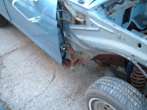 1990 Ford Ranger - This image shows the front fender and frame of a blue truck, highlighting extensive rust in the wheel well area.