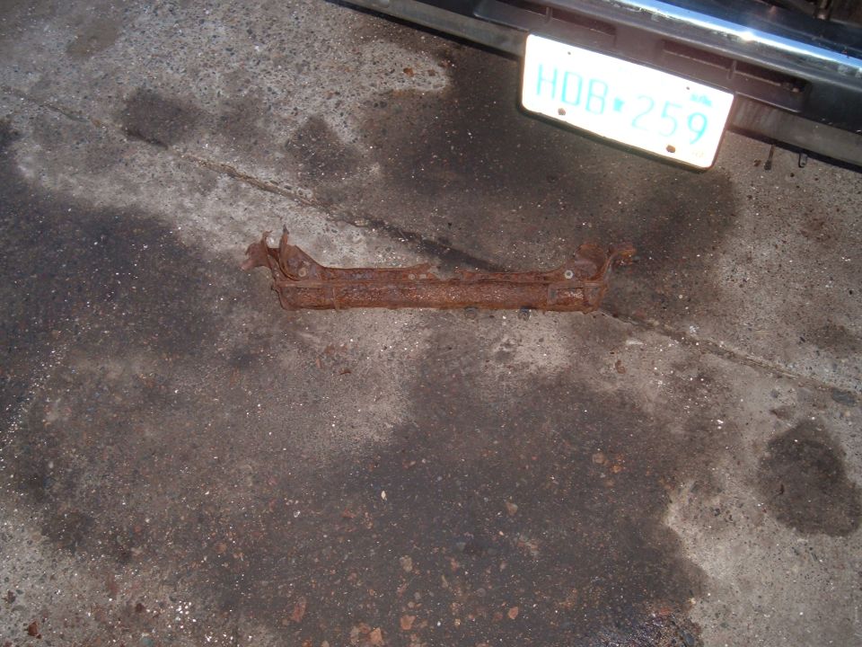 rusted metal bracket on concrete, license plate HDR-259 visible