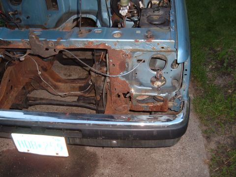 1990 Ford Ranger - The front end of a 1990 Ford Ranger shows significant rust damage, particularly around the headlight area.