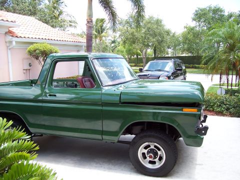 1978 Ford Bronco - A classic green Ford Bronco is parked in a driveway, with a modern SUV visible in the background.