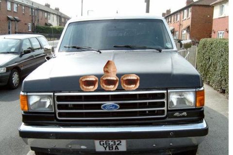 1990 Ford Bronco - A Ford truck is parked on a street with a humorous decal applied to its hood.