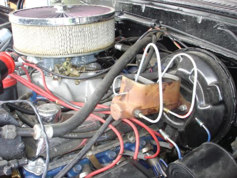 1979 Ford Bronco - Close-up view of an engine bay, highlighting the air filter, carburetor, and brake booster assembly.