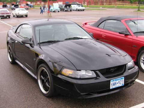 1989 Ford Mustang - Black Ford Mustang GT with custom wheels at a car show.