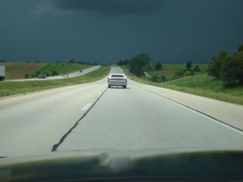 1992 Ford Crown Victoria - Driving on the highway with a 1992 Ford Crown Victoria ahead under stormy skies.