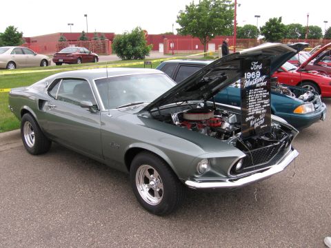 1989 Ford Mustang - A 1969 Ford Mustang is displayed with its hood open, revealing the engine compartment.
