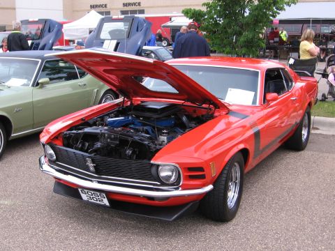 1989 Ford Mustang - A red 1970 Ford Mustang Boss 302 is displayed with its hood open at a car show.
