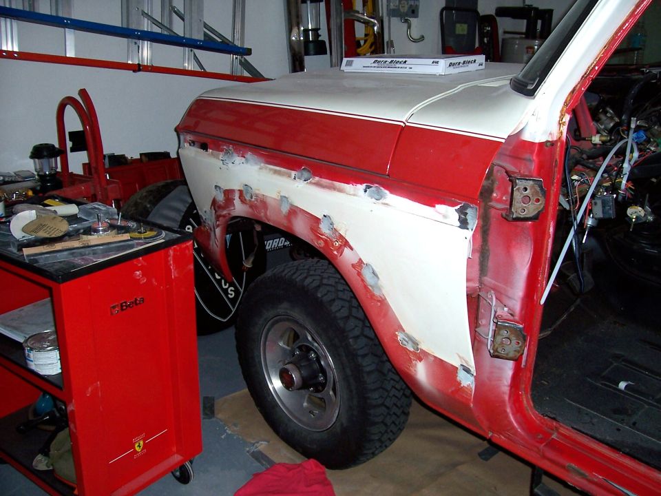 1978 Ford Bronco fender being prepped for paint, showing body filler and primer