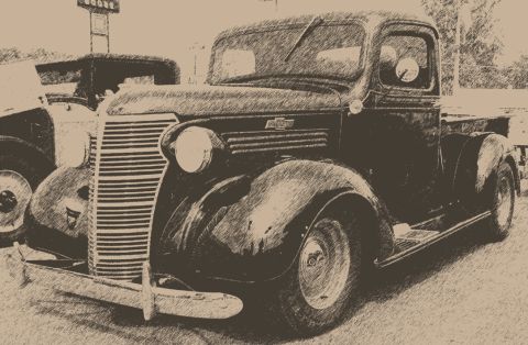 1940 Chevrolet Suburban - A vintage Chevrolet pickup truck is parked next to another vehicle, with a sign in the background.