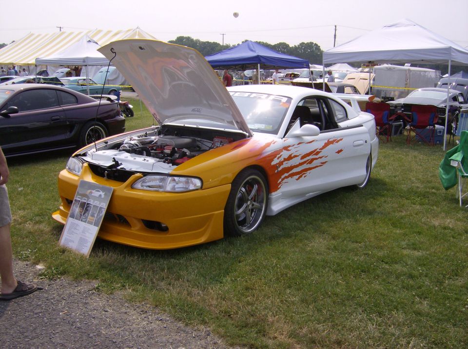 White and yellow custom coupe with flame graphics and hood open