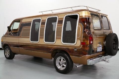 1978 Ford E250 - This customized van features a distinctive wood grain and stripe paint scheme, with a spare tire on the back.