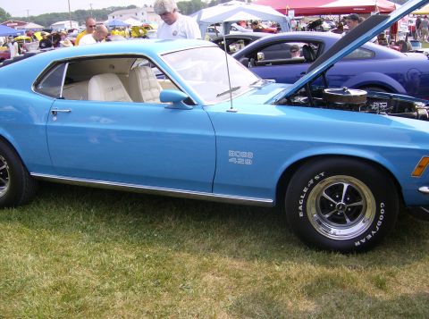 1970 Ford Ranchero - A blue 1970 Ford Ranchero with a BOSS 429 designation is displayed with its hood open at an outdoor event.