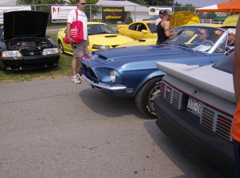 1970 Ford Ranchero - A blue classic car is parked at an outdoor event, with people and other cars around.