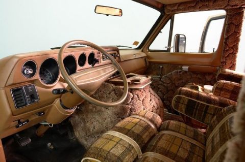 1978 Ford E250 - Interior view of a van plaid upholstery and wood-grain accents.