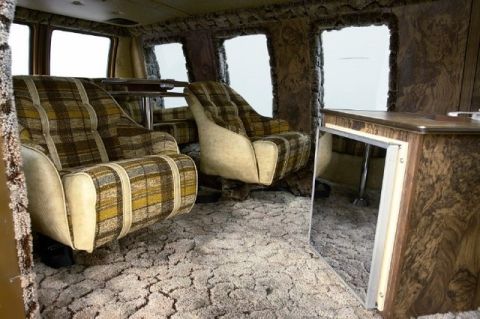 1978 Ford E250 - The interior of a van shows plaid seats and wood paneling, with no visible year identification.