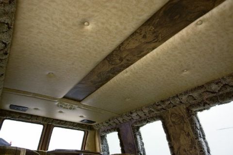 1978 Ford E250 - The interior of a van features a unique design with wood-grain trim and textured upholstery on the ceiling and walls.