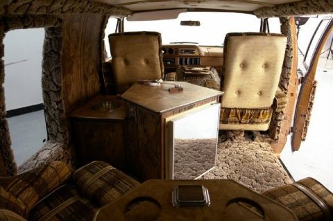 1978 Ford E250 - Custom interior of a van features wood paneling, plaid seats, and a sink area.