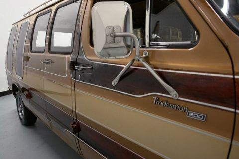 1978 Ford E250 - This van features a distinctive brown and wood-grain stripe pattern along its side, with 'Tradesman 200' badging visible.