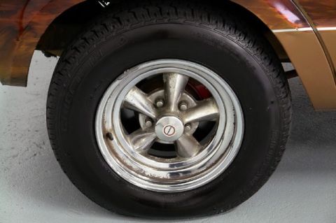 1978 Ford E250 - Close-up of a chrome five-spoke wheel and red brake caliper on a vintage van.