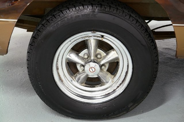 Close-up of a chrome five-spoke wheel with a Mohawk tire on a vehicle