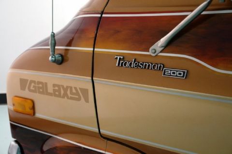 1978 Ford E250 - This van features a 'Tradesman 200' badge and a 'Galaxy' decal on its woodgrain-striped side.