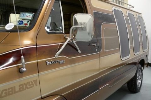 1978 Ford E250 - This van features a distinctive stripe pattern and tinted windows, with 'Tradesman 200' badging visible on the side.